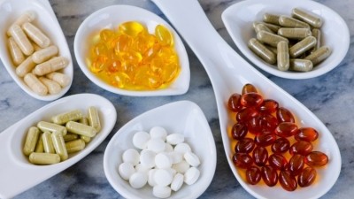 Different colour vitamins presented on different spoons place on a table © Getty Image