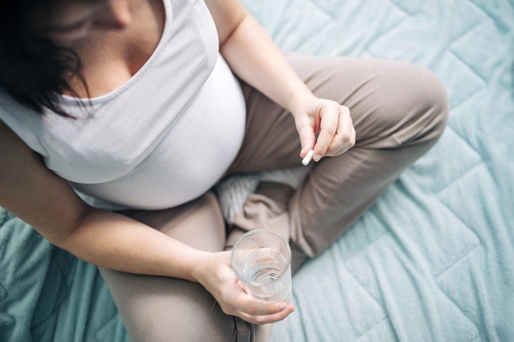 A pregnant woman taking a pill. ©Getty Images 