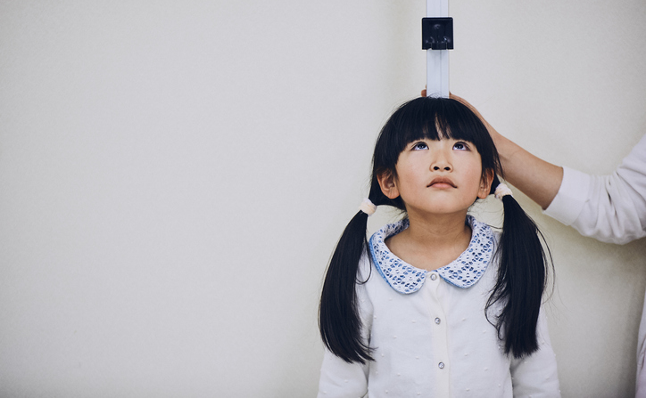 A young girl taking her height measurement. ©Getty Images 